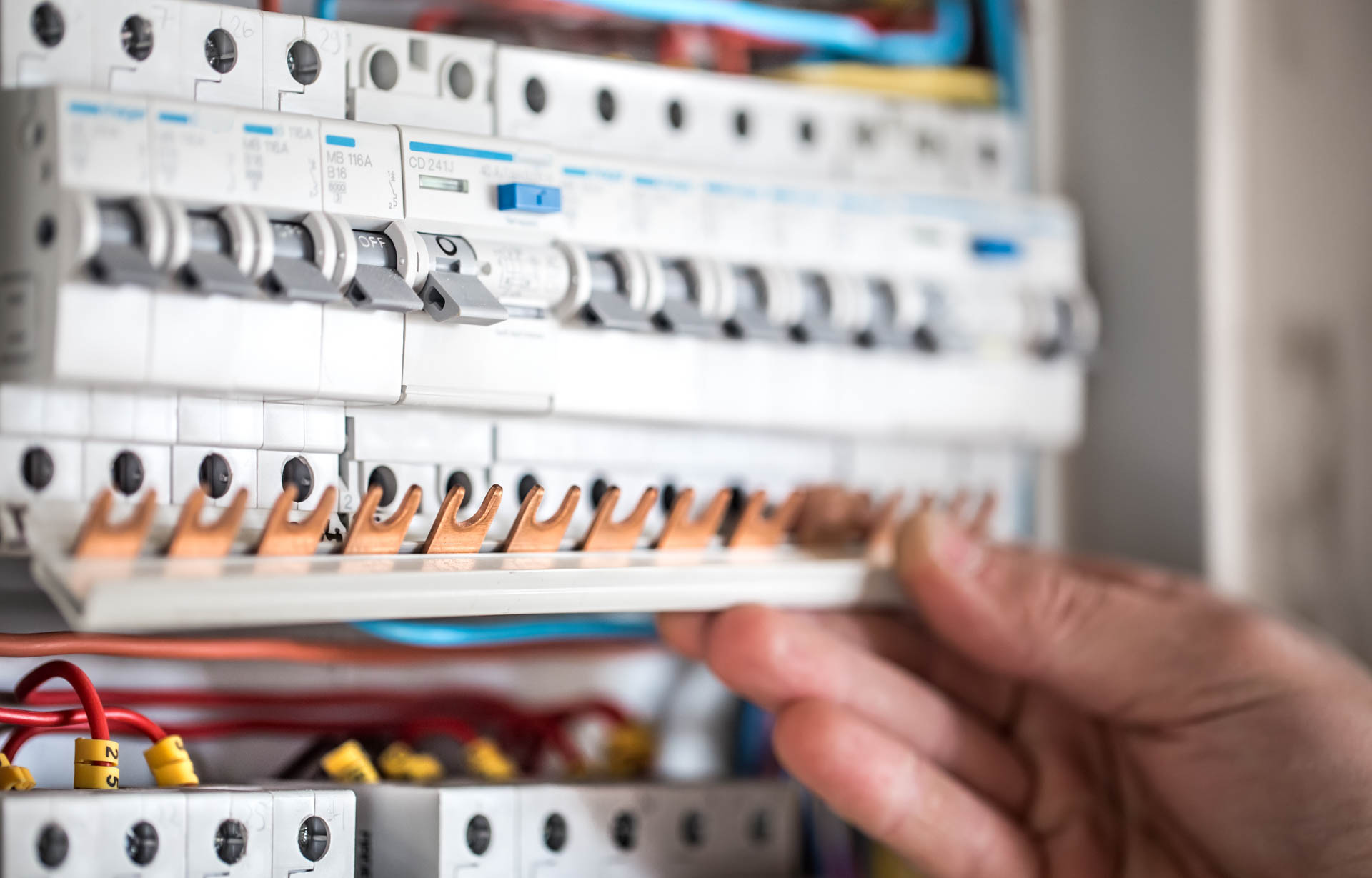 Man, an electrical technician working in a switchboard with fuse